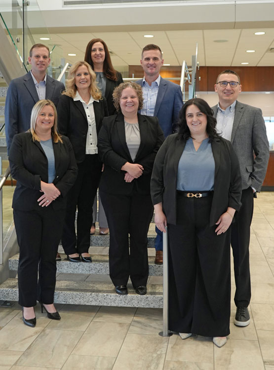 Eight professionals standing on a staircase
