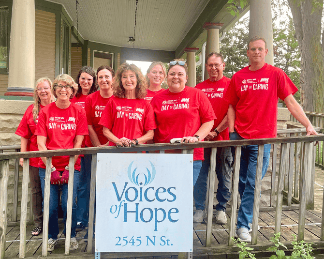 Cornhusker Bank team volunteering at Voices of Hope. Team photo on the front porch.