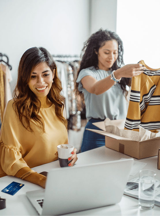 Photo of two young women working in a dry cleaners business.