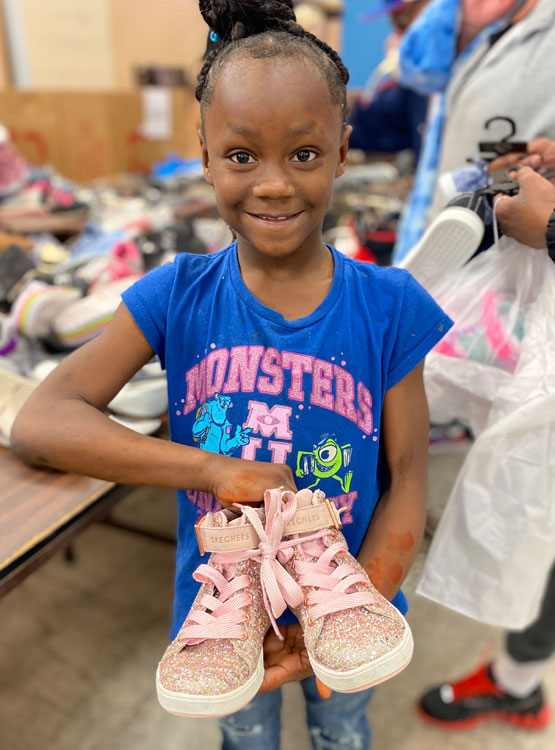 Young girl picking out shoes at the Day Without Shoes event.